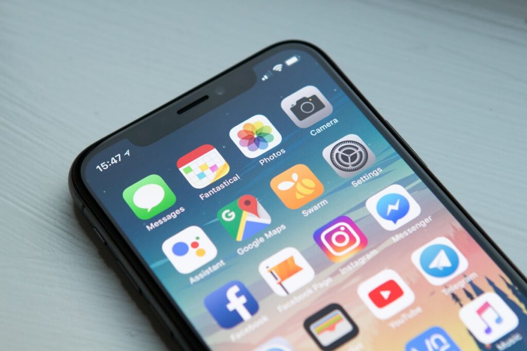 Un iPhone et un MacBook côte à côte — les réseaux sociaux vs un site web professionnel